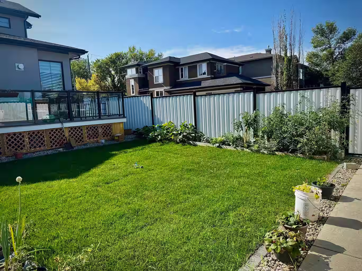 White residential fence installed by a professional fencing contractor in a backyard setting